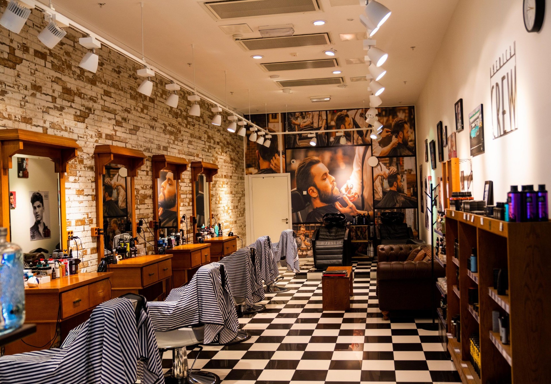 Barbershop med tegelvägg, schackrutigt golv och barberarstolar